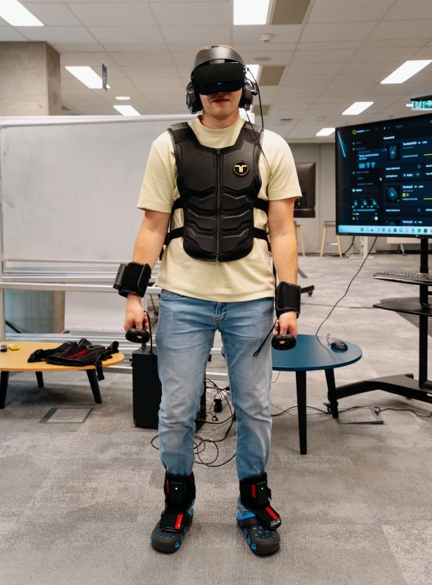 mężczyzna w przestrzeni nowoczesnego biura ubrany w zbroję haptyczną bHaptic i oculary VR