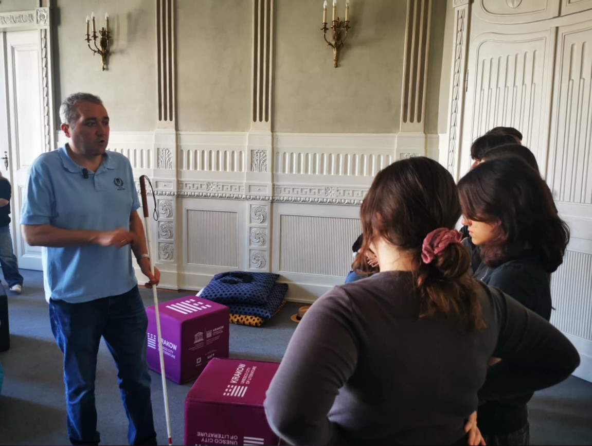 Tomek KOźmiński tłumaczy licealistom zasady asystowania osobie niewidomej. 