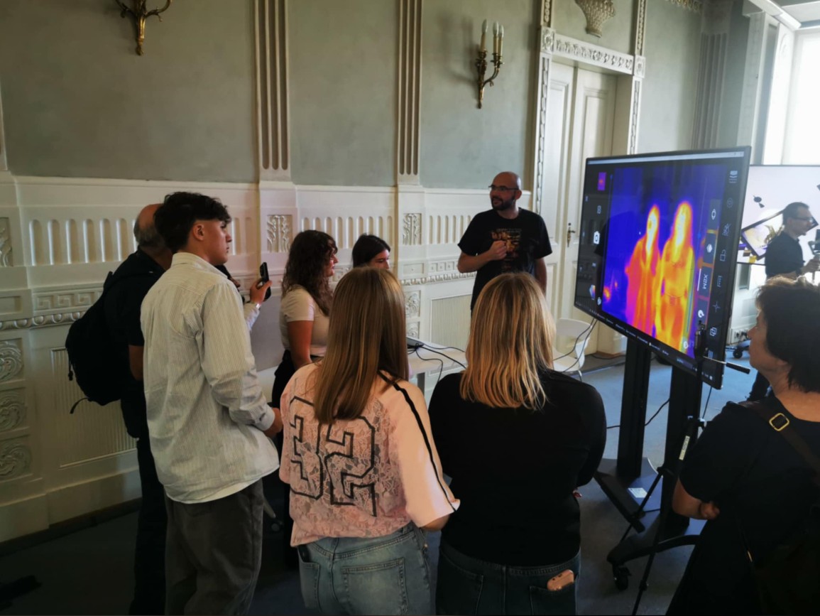 Otoczone ludźmi stanowisko warsztatowe prezentujące za pomocą termowizji ograniczenia w ludzkiej percepcji.